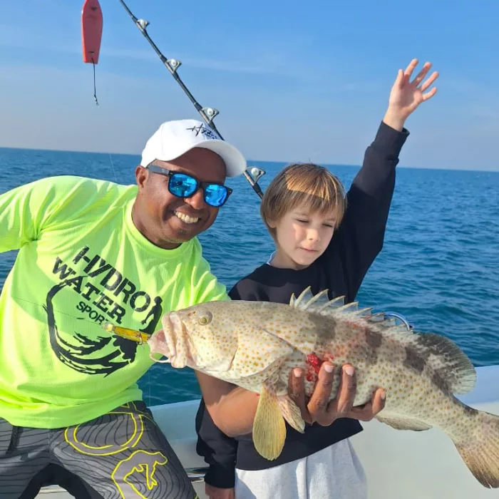 Fishing instructor and kid with a fish