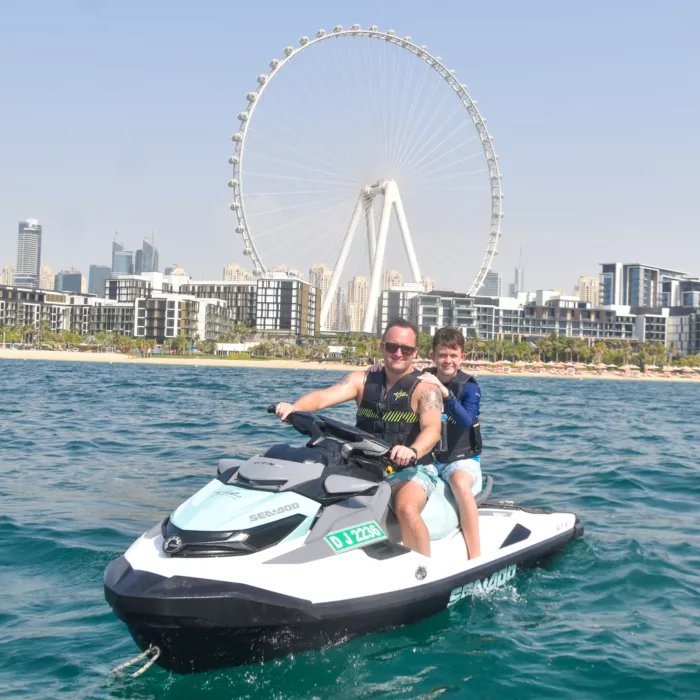 Father and son jet skiing in front of Ain Dubai