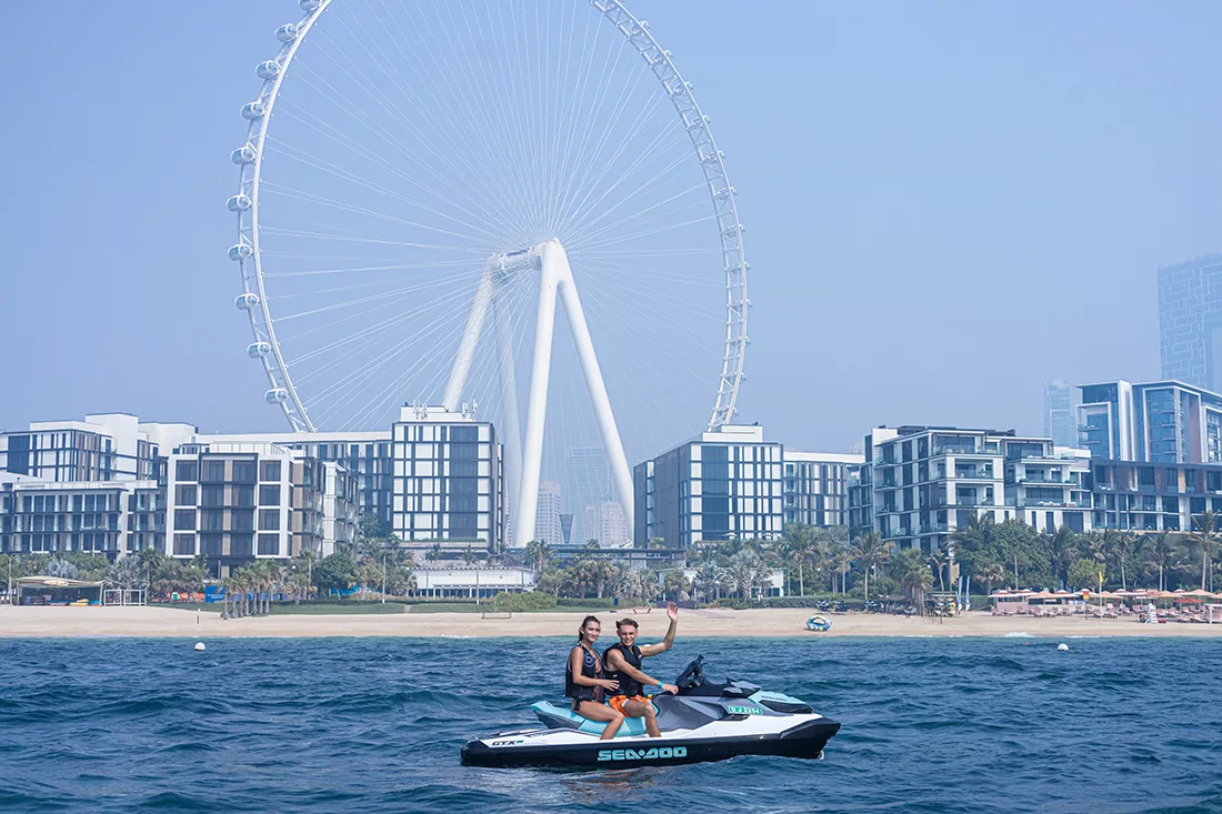 A beginner couple jet skiing in front of Ain Dubai in the UAE