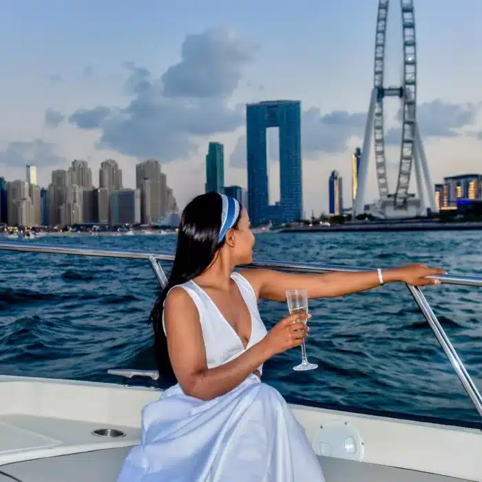 Lady enjoying a mini yacht cruise in Dubai looking at Ain Dubai