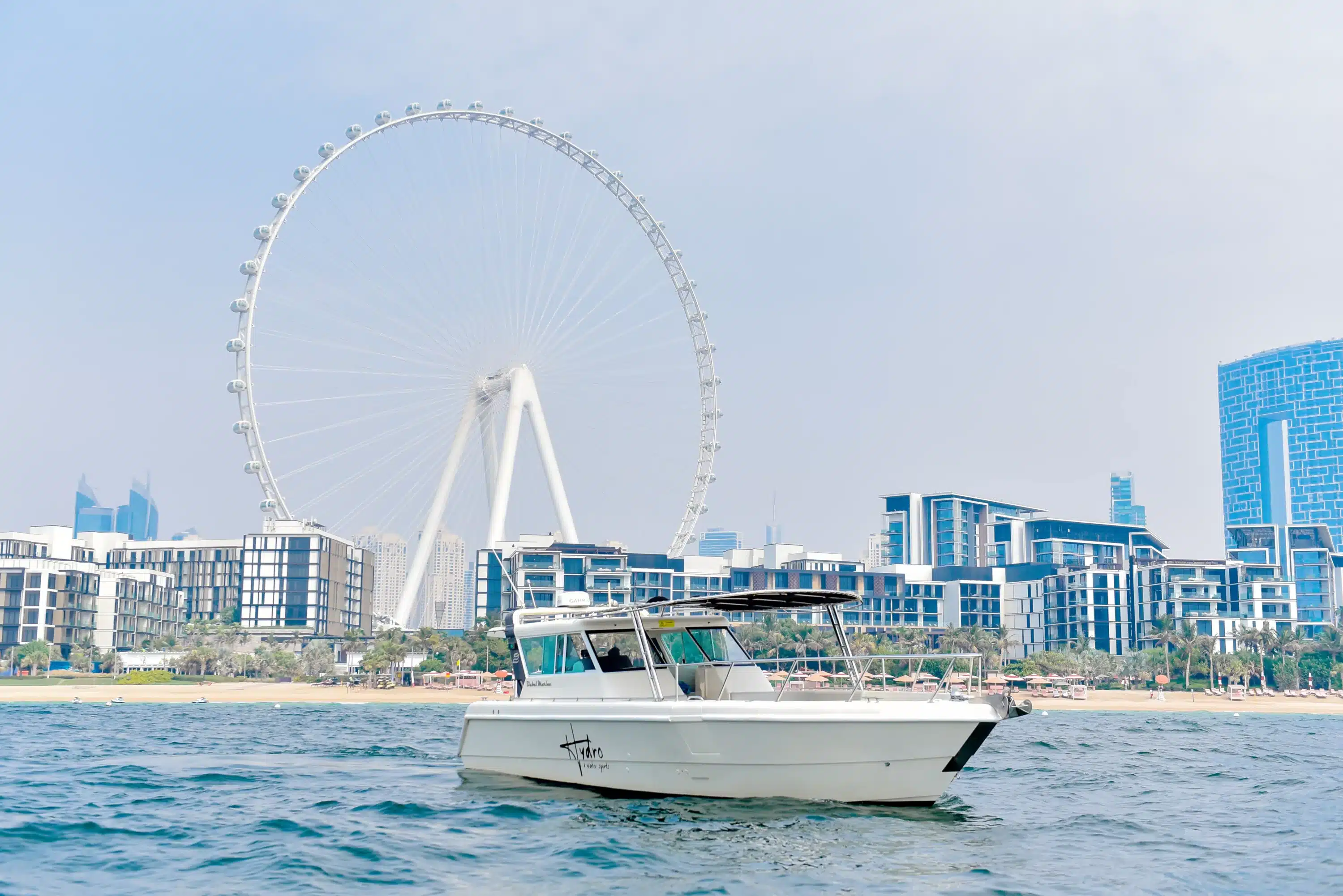 Mini yacht cruising in front of Ain Dubai