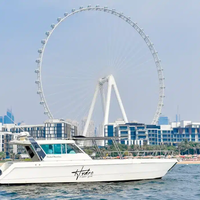 Mini yacht cruising in front of Ain Dubai