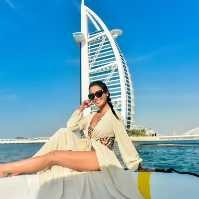 Lady enjoying a mini yacht cruise in Dubai in front of Burj Al Arab